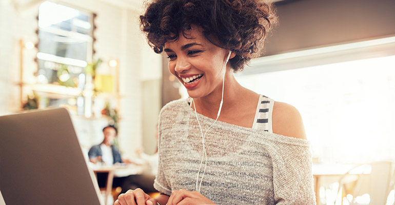 Image,Of,Happy,Woman,Using,Laptop,While,Sitting,At,Cafe.